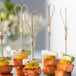 A bunch of Bamboo by EcoChoice heart-shaped bamboo skewers with food on them.