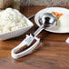 A white metal Vollrath disher filled with mashed potatoes on a table.