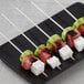 A plate of watermelon, cucumber, and feta cheese on EcoChoice round wooden skewers.