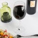 A Chef & Sommelier tall wine glass filled with wine next to a plate of food.