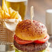 Bamboo "Medium Rare" meat marker in a burger with fries on a plate.