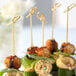 A plate of food on skewers with a Bamboo by EcoChoice bamboo knot skewer.