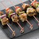 Bamboo skewers with chicken, vegetables, and peppers on a plate.