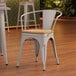 A Lancaster Table & Seating gray metal arm chair with natural wood seat and back.