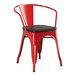 A red Lancaster Table & Seating metal arm chair with a black wood seat and back.