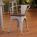 A Lancaster Table & Seating gray metal chair with a black wood seat.