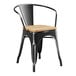 A Lancaster Table & Seating black metal chair with a natural wood seat.