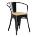 A Lancaster Table & Seating black metal arm chair with a natural wood seat.