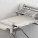 A white conveyor belt with dough on it.