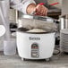 A person cooking rice in a Galaxy commercial rice cooker.