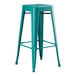 A teal Lancaster Table & Seating outdoor barstool with metal legs.