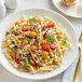 A plate of Barilla gemelli pasta with tomatoes and mushrooms.