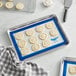 A tray of cookies on a blue Vollrath baking mat.