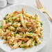 A plate of Barilla rigatoni pasta with vegetables and meat.