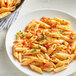 A plate of Barilla Pennoni Rigati pasta with tomato sauce and parsley.