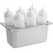 A stainless steel tray with white plastic squeeze bottles on it.