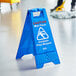 A blue Lavex caution wet floor sign on the floor.