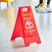 A red Lavex caution wet floor sign on the floor.