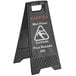 A black Lavex caution wet floor sign with white text.