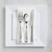 A Visions white plastic plate with silver Classic flatware on it.