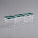 A row of Carlisle plastic containers with green lids.