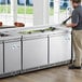 An Avantco stainless steel refrigerated salad bar on a counter in a kitchen.