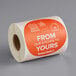 A roll of TamperSafe round orange food labeling stickers with the words "From Our Kitchen To Yours" on the counter.