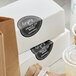 A stack of food boxes with black TamperSafe labels.