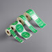 A roll of green and white TamperSafe labels with the words "Enjoy With Peace Of Mind" on a white background.