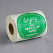 A roll of green TamperSafe paper labels with white text that reads "Enjoy With Peace Of Mind"