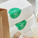 A stack of white boxes with green TamperSafe labels.