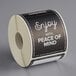 A roll of black TamperSafe paper labels with the words "Enjoy with Peace of Mind" on it.