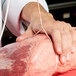 A person holding a piece of meat with Choice #24 Butcher Sausage Twine.
