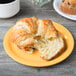 A croissant on a GET Diamond Mardi Gras melamine plate.