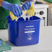 A blue Noble King-Pail 8 quart multi-purpose cleaning pail being used with a yellow sponge and gloves.