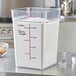 A Carlisle clear square food storage container with flour inside.
