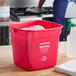 A red Noble King-Pail 10 quart sanitizing pail filled with soapy water.