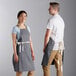 A man and woman wearing gray Choice restaurant aprons with natural webbing accents.