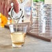 A hand pouring a drink into an Acopa Endure Tritan plastic rocks glass.