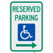 A green and white aluminum parking sign with a wheelchair and "Handicapped Reserved Parking" and a right arrow.