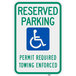 A green and blue aluminum parking sign that says "Handicapped Reserved Parking / Permit Required / Towing Enforced" with white text and symbols.