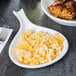 A Tuxton white china fry pan server with a bowl of rice and chicken on a table.