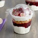 A Dart SafeSeal plastic snack cup filled with food and covered with a dome lid.