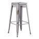 A Lancaster Table & Seating distressed nickel gray metal barstool with a square seat.