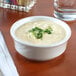 a bowl of soup with green garnish on top