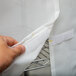 A hand holding a white Metro shelf cart cover with yellow Velcro tape.