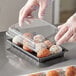 A clear plastic extra large food container with a lid, holding several round pastries.