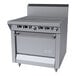 A commercial stainless steel range with two hot top sections, multiple control knobs, and a standard oven.