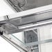 A close-up of a glass shelf with a metal frame inside a white Avantco refrigerated bakery display case.