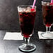 Two Anchor Hocking soda glasses filled with ice and drinks with pink straws.